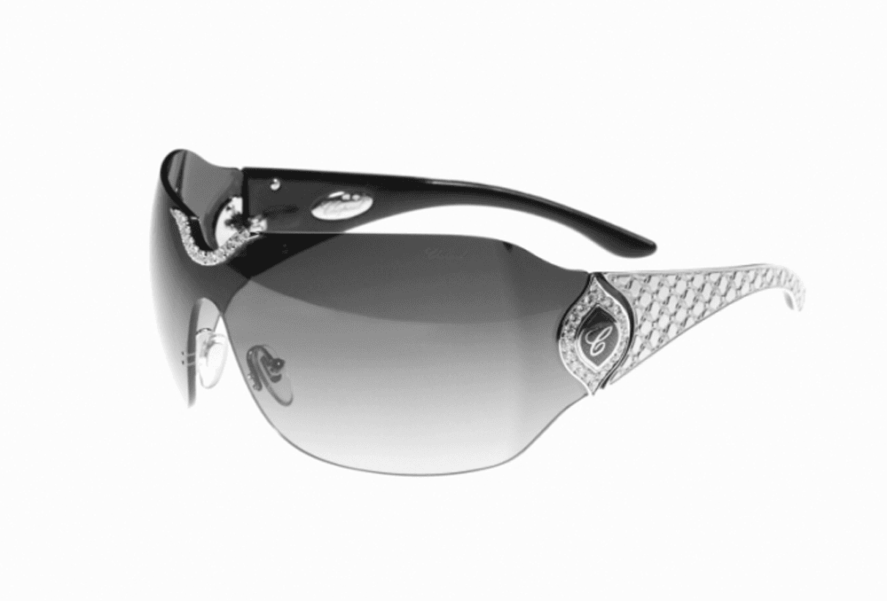 A pair of sleek, modern sunglasses with a black frame and gradient lenses. The temples feature intricate silver detailing and embellishments. The design exudes luxury and style.